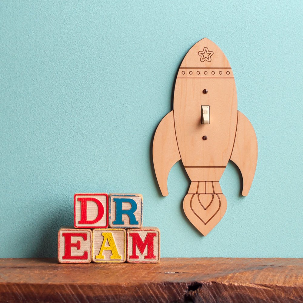 A collection of playful wooden handmade light switch plate covers for nursery & kids' themed spaces by Graphic Spaces