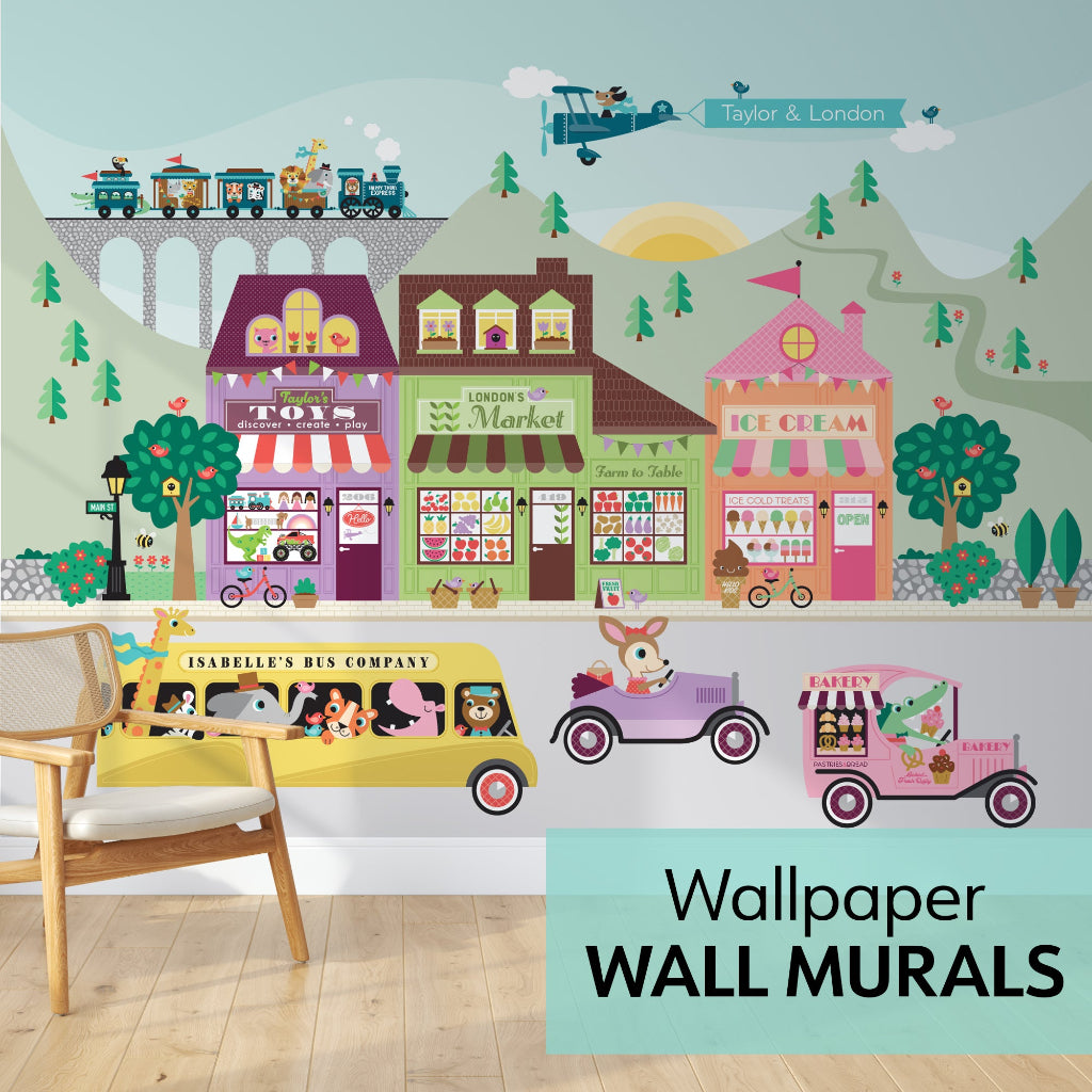 Personalised Happy Town wallpaper wall mural – colourful mountain-backdrop village with toy shop, market, pink ice-cream shop & animal vehicles, kids’ room view.