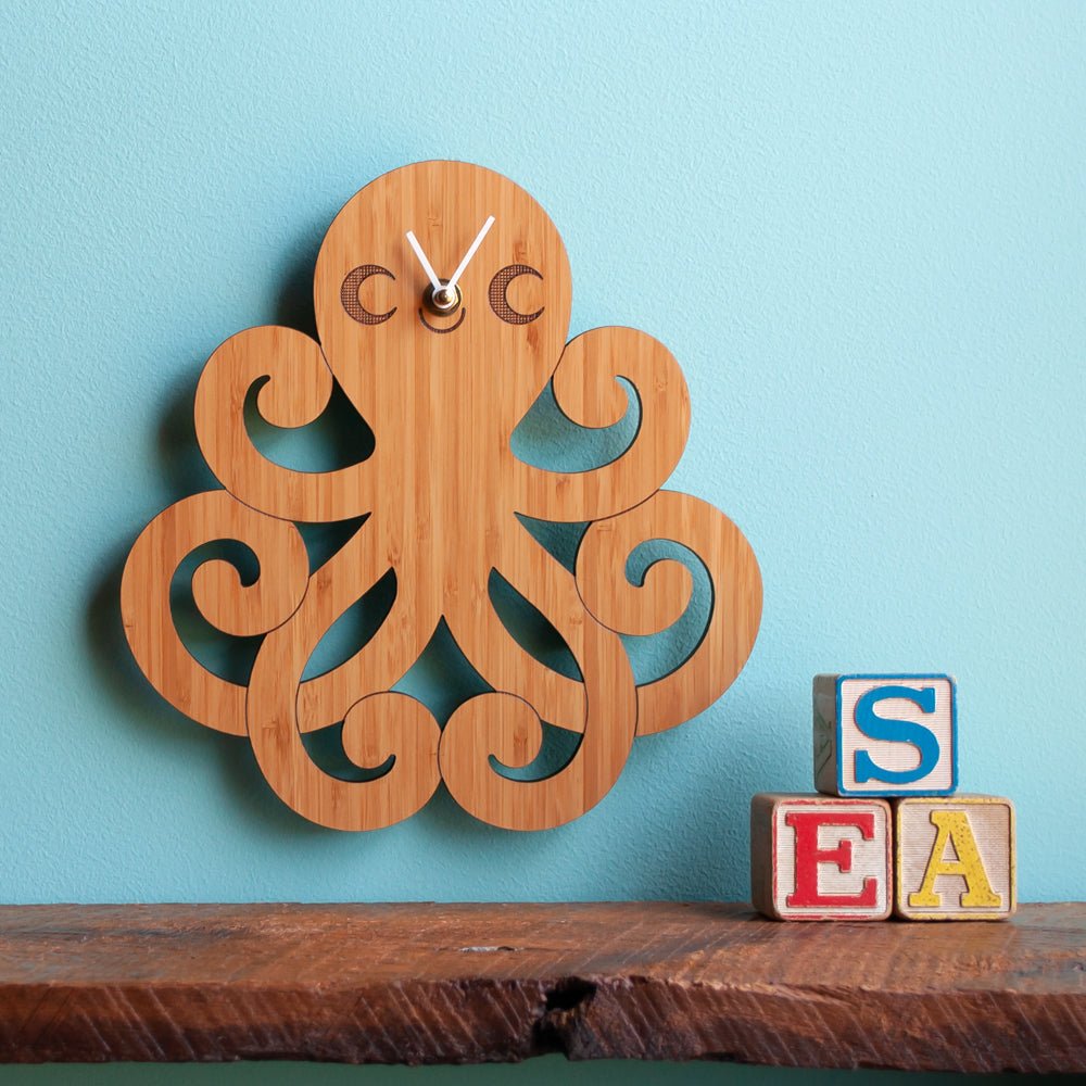 Kids Wall Clock - Octopus (Wood) Cherry - Nursery - Shown with white hands on blue wall - Handmade in TN - Graphic Spaces