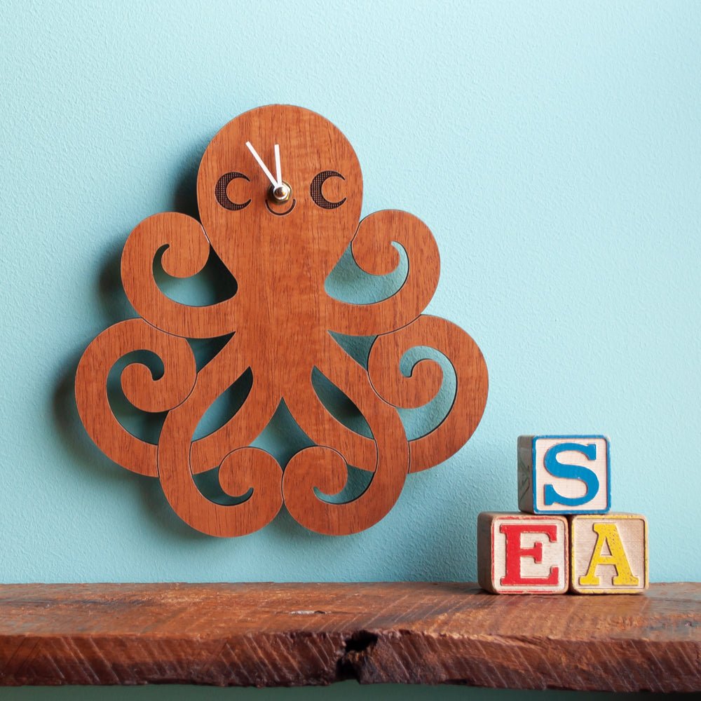 Kids Wall Clock - Octopus (Wood) Cherry - Nursery - Shown with white hands on blue wall - Handmade in TN - Graphic Spaces
